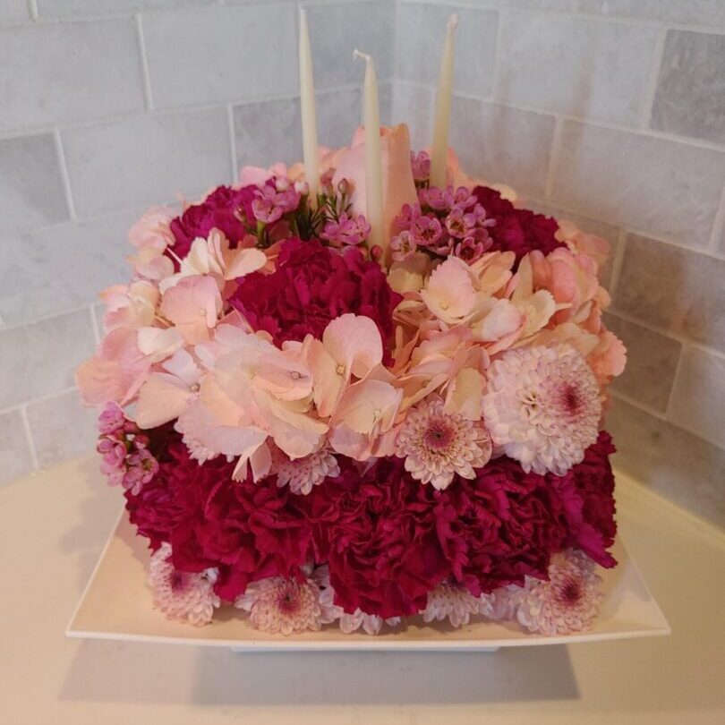 Red and light pink flowers with three candles